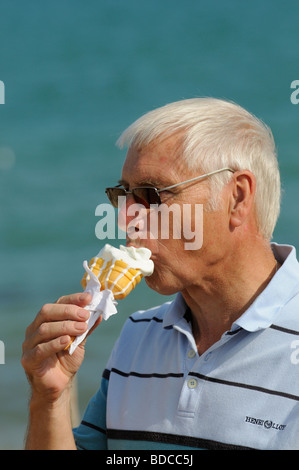 Portrait of an elderly man with grey hair eating an ice cream cornet Stock Photo