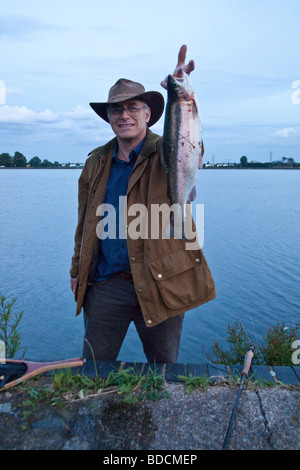 Trout fly fisherman with a 3lb rainbow trout at Walthamstow Reservoirs London England. Stock Photo