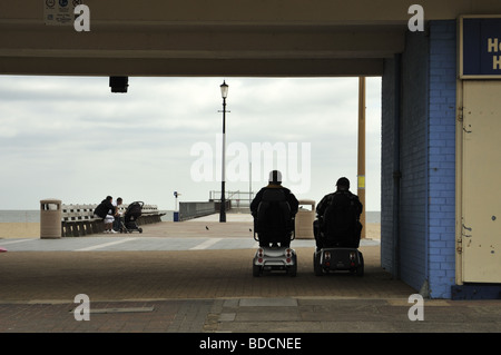 A couple on mobility scooters, Great Yarmouth, Norfolk, UK. Stock Photo