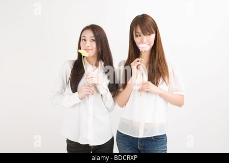 Two young women holding flowers Stock Photo