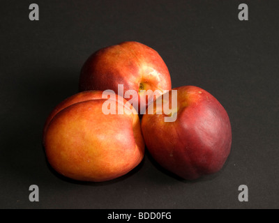 three nectarines on a black background Stock Photo