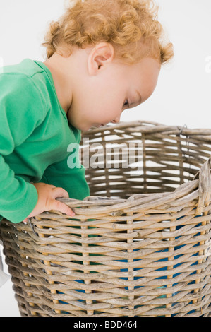 Baby boy looking into a wicker basket Stock Photo