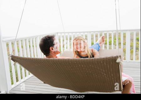 Girl sitting on a swing with her father