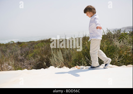 Boy walking at the poolside Stock Photo
