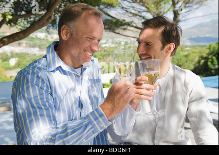 Two friends toasting with wine glasses Stock Photo