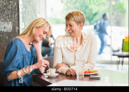 Two women sitting in a restaurant and smiling Stock Photo