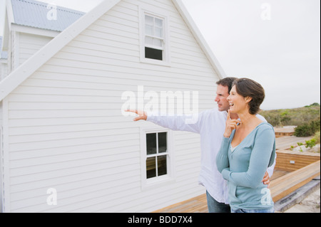 Man pointing towards a house with a woman standing beside her Stock Photo