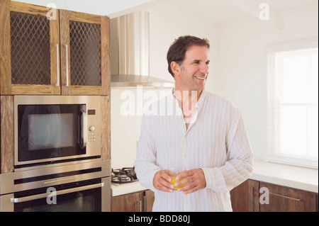 Man holding a glass of juice and smiling Stock Photo