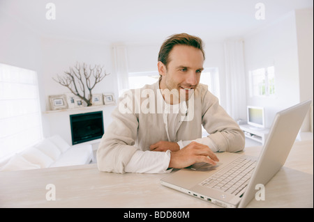 Man working on a laptop and smiling Stock Photo