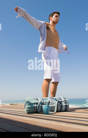 Man standing on a boardwalk with his arm outstretched Stock Photo