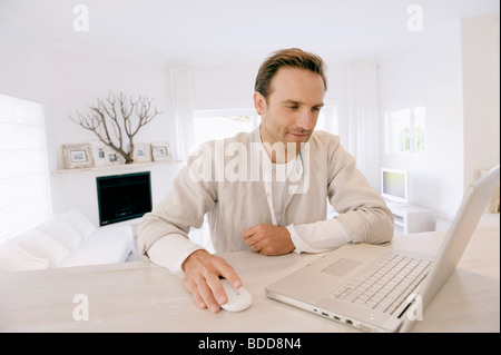 Man working on a laptop and smiling Stock Photo