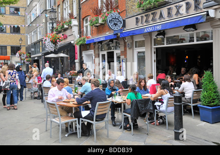 Pizza Express restaurant with people eating out dining outdoors in St Christophers Place off Oxford Street alfresco meals summer in London West End UK Stock Photo