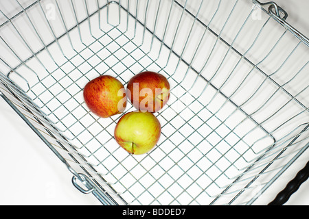 solitary overhead view of a wire shopping wire basket with three apples Stock Photo