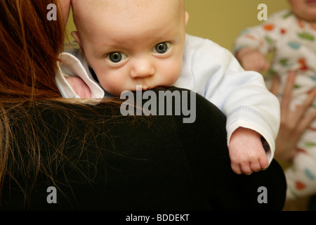 CUTE BABY, MOTHER, NURSING: A three month old baby boy child is held on the shoulder being nursed by his mum mother. Model released Stock Photo