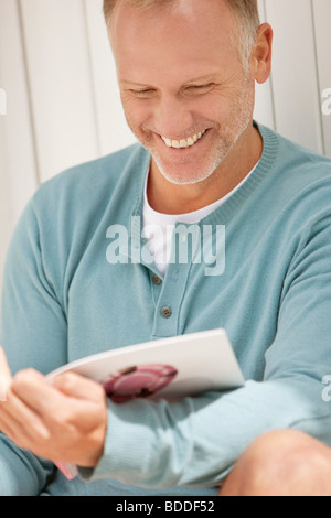 Man reading a magazine and smiling Stock Photo