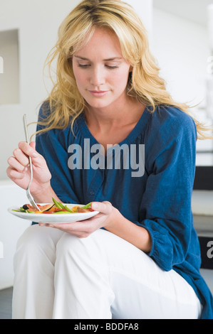 Woman holding a plate of fruit salad Stock Photo