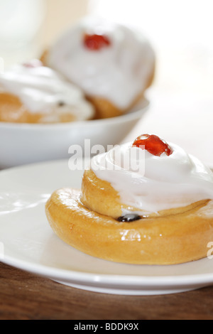 Freshly Baked Sweet Iced Fruit Buns Topped With A Cherry With No People Stock Photo