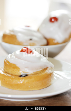 Freshly Baked Sweet Iced Fruit Buns Topped With A Cherry With No People Stock Photo