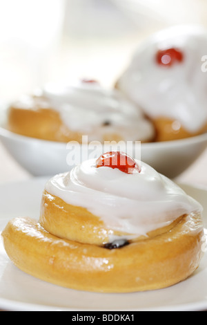 Freshly Baked Sweet Iced Fruit Buns Topped With A Cherry With No People Stock Photo