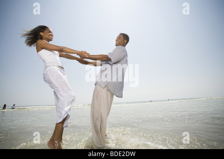 African American Couple playing on the beach Stock Photo