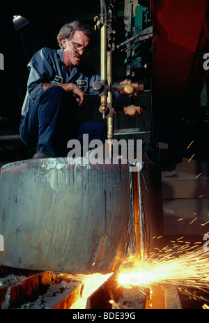 Worker operating an automated cutting machine at a metal production plant near Cleveland, Ohio, USA Stock Photo