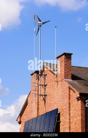 Wind generator and solar panels affixed to the Southerly  wall of a residential house in Leamington Spa, Warwickshire, UK. Stock Photo