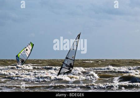 Two windsurfers in the sea off Camber Sands in Sussex.  Photo by Gordon Scammell Stock Photo