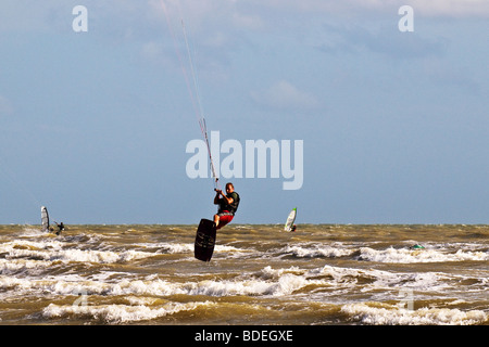 A parasurfer performing acrobatic jumps in the sea off Camber Sands in Sussex.  Photo by Gordon Scammell Stock Photo