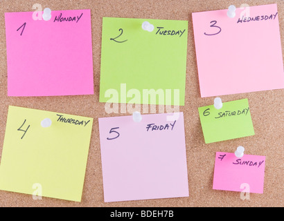 Colorful sticky notes attached to a corkboard Stock Photo