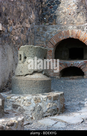 An ancient millstone and an oven in the ruins of a bakery at Pompeii, Italy. Stock Photo