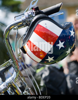 Harley Davidson motorcycle with a custom American 'stars and stripes flag' helmet on the handlebars Stock Photo