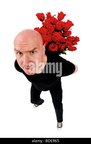 bald headed man hinding a bunch of red roses behind his back Stock Photo