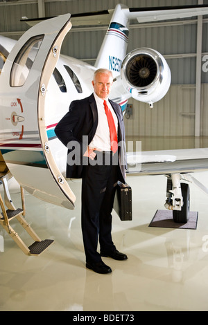 Middle-aged businessman leaving private jet plane Stock Photo