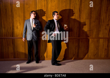Vintage portrait of two businessmen in boardroom having a drink Stock Photo