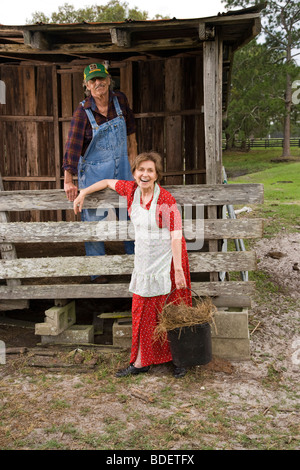 Senior couple on farm working near barn Stock Photo