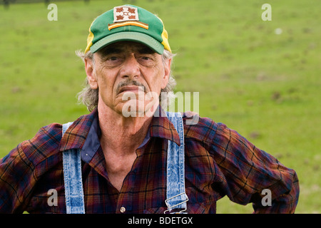 Portrait of senior man wearing green cap standing in field Stock Photo
