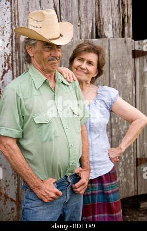 Portrait of senior couple standing outside barn Stock Photo