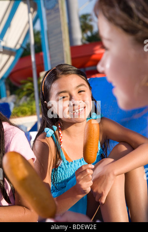 Children at waterpark eating corn dogs Stock Photo