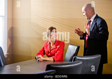 Two businesspeople chatting in boardroom Stock Photo