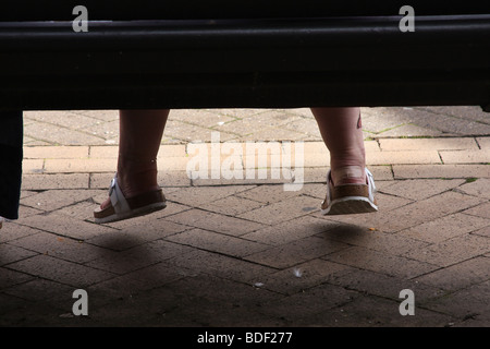 Pair of ladies feet with plasters and slip on shoes. Stock Photo