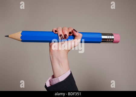Female hand holding giant blue pencil Stock Photo