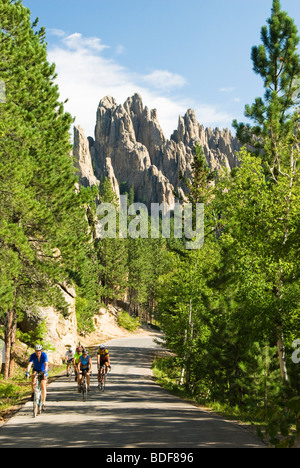 Cyclists on the Needles Highway with the Cathedral Spires in the background. Stock Photo