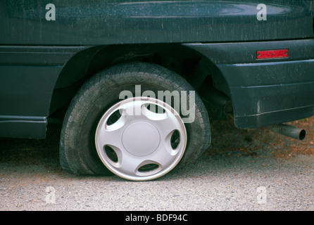 Deflated Flat Tyre / Tire on Car due to Puncture on Road Stock Photo