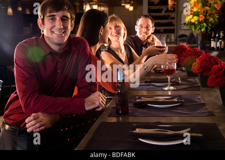 Young man with friends hanging out at restaurant Stock Photo