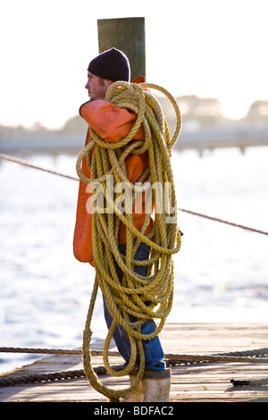 Portrait of fisherman on pier holding rope Stock Photo