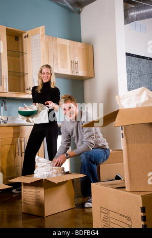 Young couple unpacking moving boxes in new home Stock Photo
