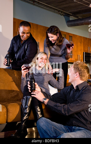 Multi-ethnic couples having drinks together in modern loft Stock Photo