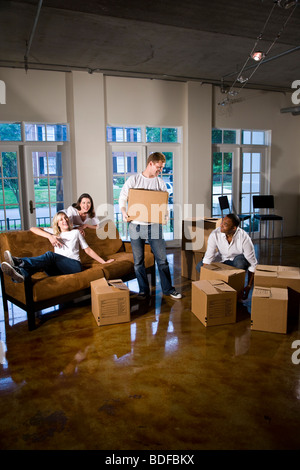 Multi-ethnic friends and couples with moving boxes in living room Stock Photo
