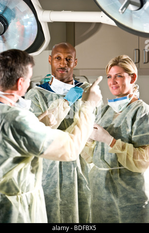 Surgeons conversing in operating room after medical procedure Stock Photo