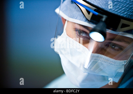Close-up portrait of healthcare worker with surgical mask and headlamp Stock Photo